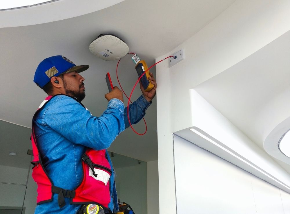 Se muestra un Access point Wifi 7 instalado en una empresa de la zona metropolitana de Jalisco, así mismo el técnico está corroborando que el cableado que alimenta al Access point esté listo.